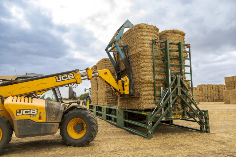 jcb fastrac loading bales onto a bale trailer